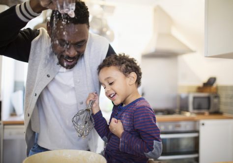 Playful father and son baking in kitchen